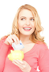 Image showing lovely woman with piggy bank and money