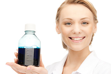 Image showing lab worker holding up bottle with blue liquid