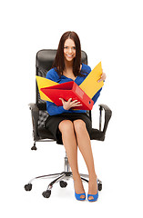 Image showing young businesswoman with folders sitting in chair