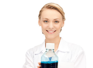 Image showing lab worker holding up bottle with blue liquid