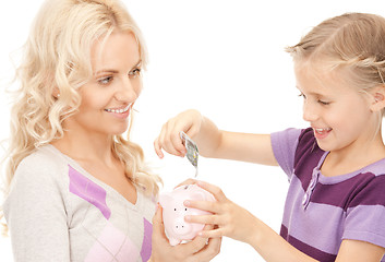 Image showing mother and little girl with piggy bank