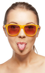 Image showing teenage girl in shades sticking out her tongue