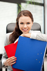 Image showing young businesswoman with folders sitting in chair