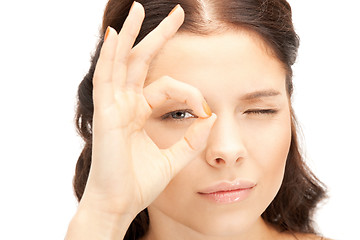 Image showing lovely woman looking through hole from fingers