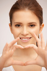 Image showing happy woman making heart gesture