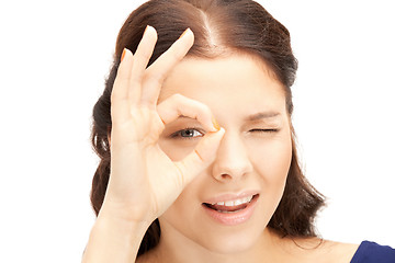 Image showing lovely woman looking through hole from fingers