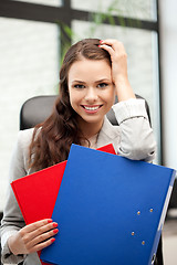 Image showing young businesswoman with folders sitting in chair