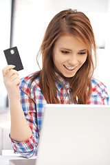 Image showing happy woman with laptop computer and credit card