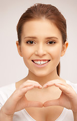 Image showing happy woman making heart gesture