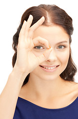 Image showing lovely woman looking through hole from fingers