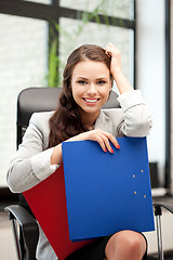 Image showing young businesswoman with folders sitting in chair