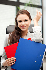 Image showing young businesswoman with folders sitting in chair