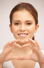 Image showing happy woman making heart gesture