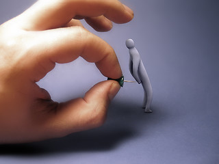 Image showing Hand holding a pin pecking a 3d person.