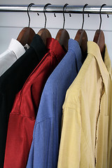 Image showing Colorful shirts on wooden hangers