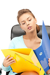 Image showing young businesswoman with folders sitting in chair