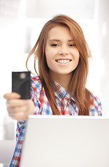 Image showing happy woman with laptop computer and credit card