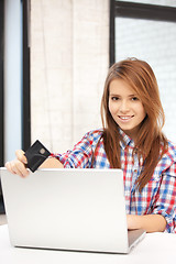 Image showing happy woman with laptop computer and credit card