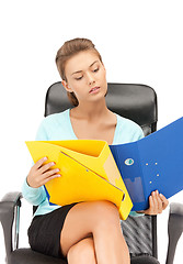 Image showing young businesswoman with folders sitting in chair