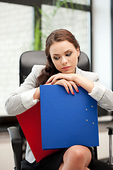 Image showing young businesswoman with folders sitting in chair