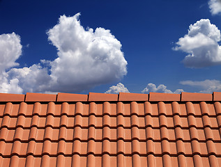 Image showing Roof tiles against blue sky with clouds