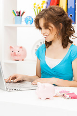 Image showing lovely woman with piggy bank and money