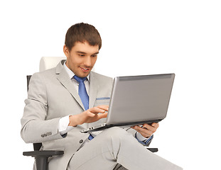 Image showing young businessman sitting in chair with laptop