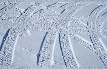 Image showing Tire tracks crossing the snowy terrain