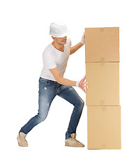 Image showing handsome builder moving big boxes