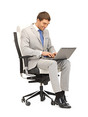 Image showing young businessman sitting in chair with laptop