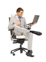 Image showing young businessman sitting in chair with laptop