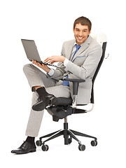 Image showing young businessman sitting in chair with laptop