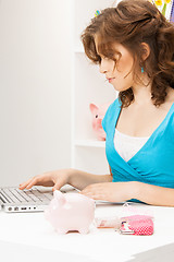 Image showing lovely woman with piggy bank and money