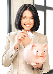 Image showing lovely woman with piggy bank and money
