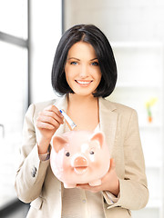 Image showing lovely woman with piggy bank and money