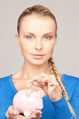 Image showing lovely woman with piggy bank and money