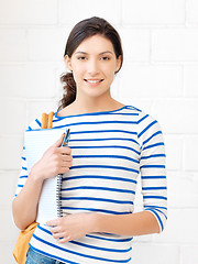 Image showing happy and smiling teenage girl with big notepad