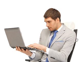 Image showing young businessman sitting in chair with laptop
