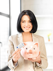 Image showing lovely woman with piggy bank and money