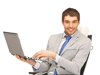 Image showing young businessman sitting in chair with laptop