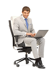 Image showing young businessman sitting in chair with laptop