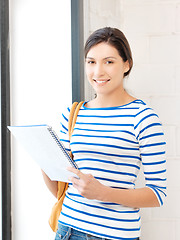 Image showing happy and smiling teenage girl with big notepad