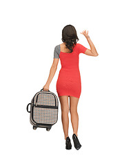 Image showing woman with suitcase waving hand