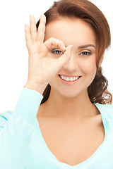 Image showing lovely woman looking through hole from fingers