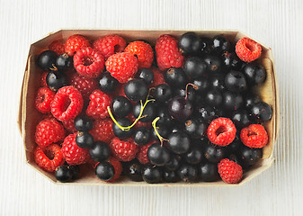 Image showing fresh raspberries and black currant berries in a box