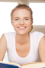 Image showing happy and smiling teenage girl with book