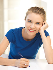 Image showing happy teenage girl with pen and paper