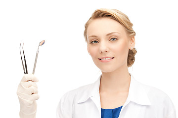 Image showing attractive female dentist with tools