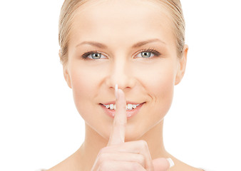 Image showing happy woman with finger on lips