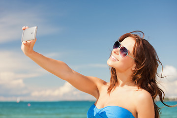 Image showing happy woman with phone on the beach